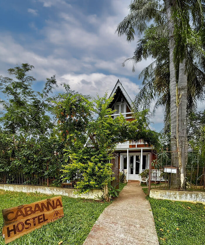 Cabanna Hostel — casa de madeira com varanda e rede em Candelária, RS