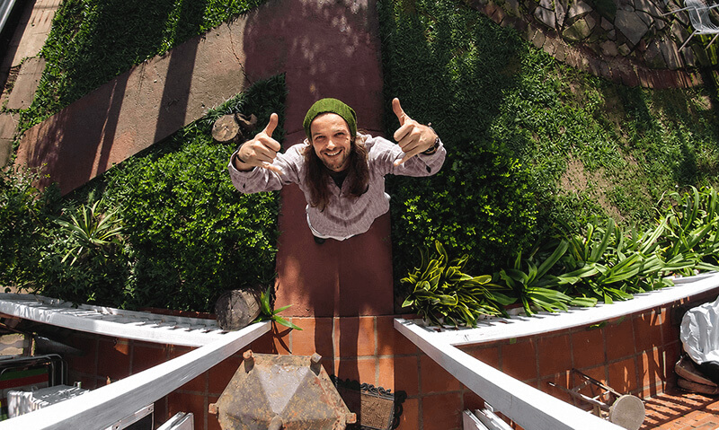 Diego Trindade, anfitrião da Cabanna Hostel, no quintal arborizado